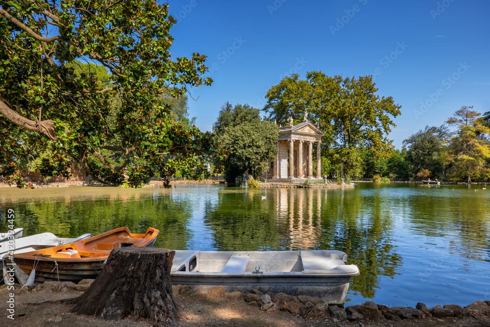 Rowboats on the small lake in Villa Borghese circling the round columned Temple of Aesculapius
