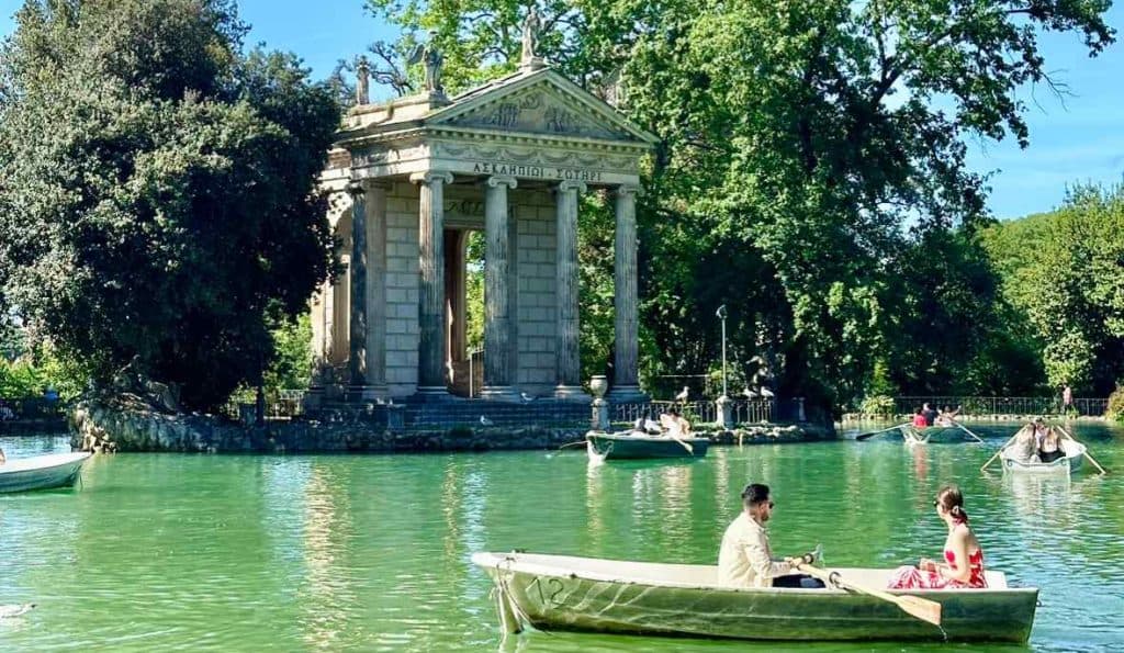 A family paddling a rented rowboat past the small island temple on the Giardino del Lago